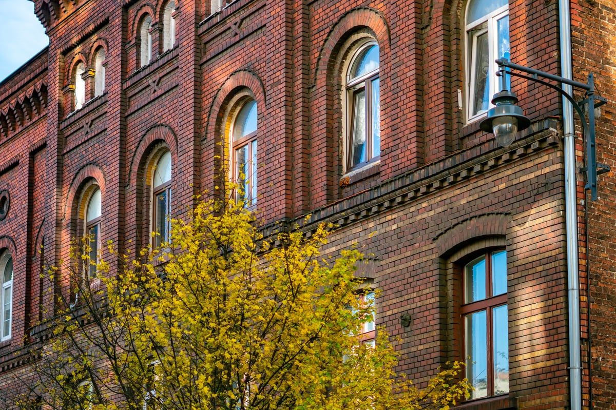 Historic brick building with arched windows and decorative architectural details representing Old Main